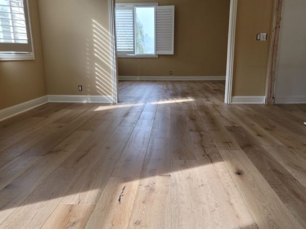 hard wood floor installation in room with brown walls